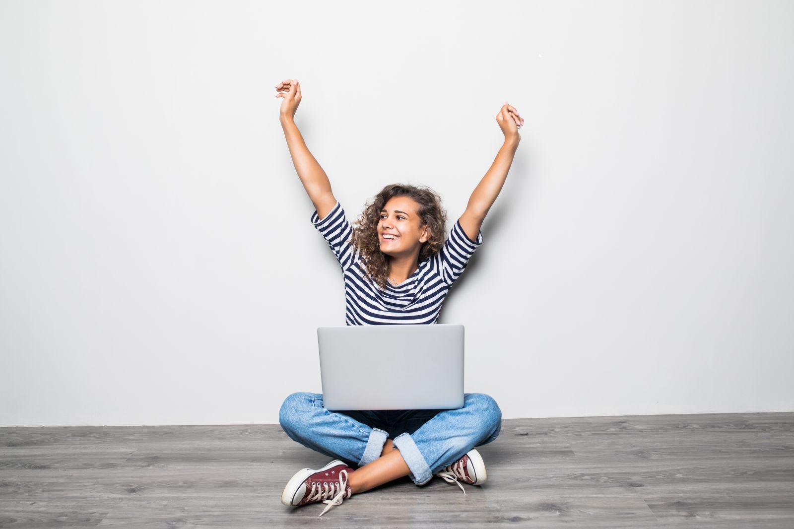 woman sitting with her hands raised to the sky