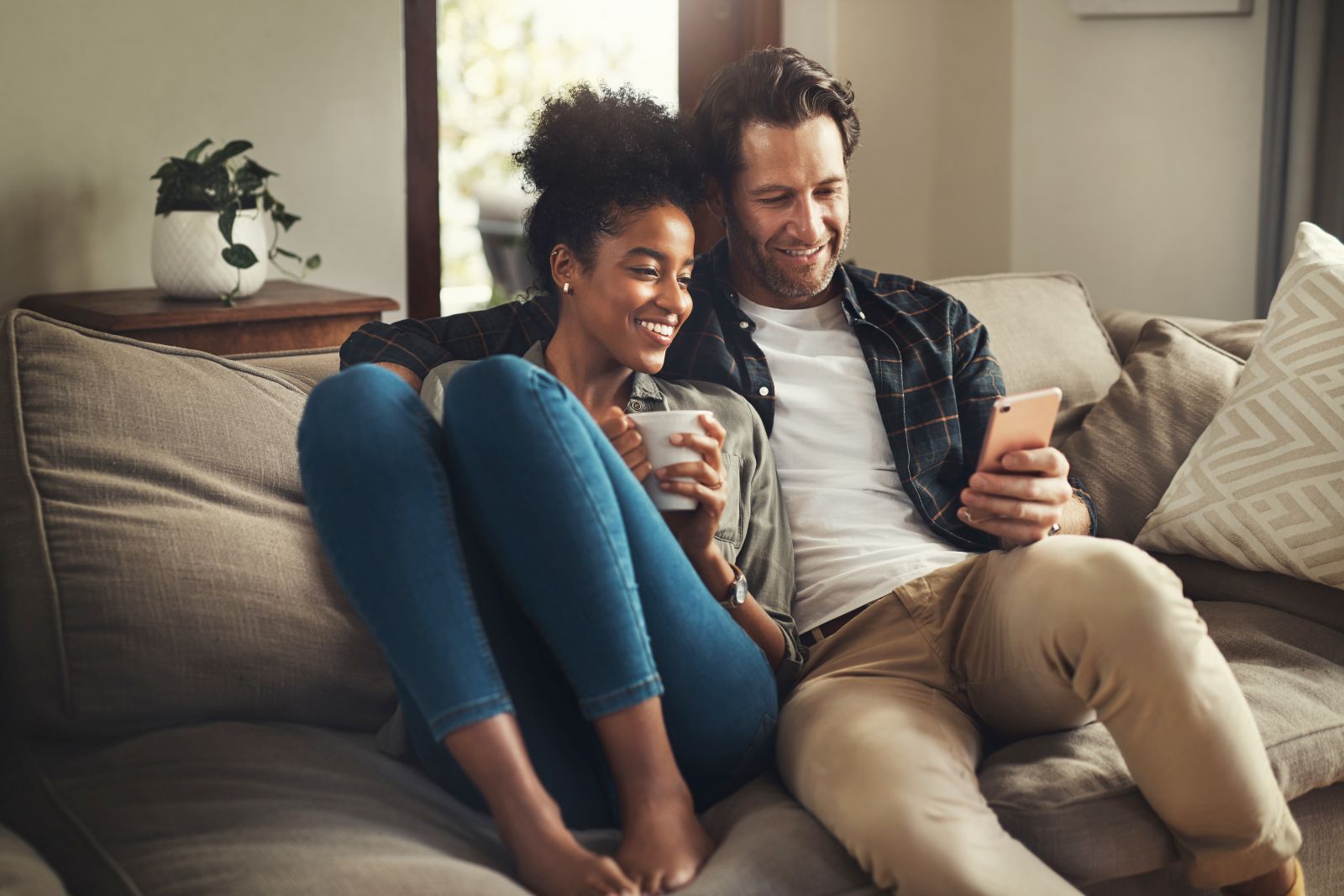 Interracial couple cuddling on couch